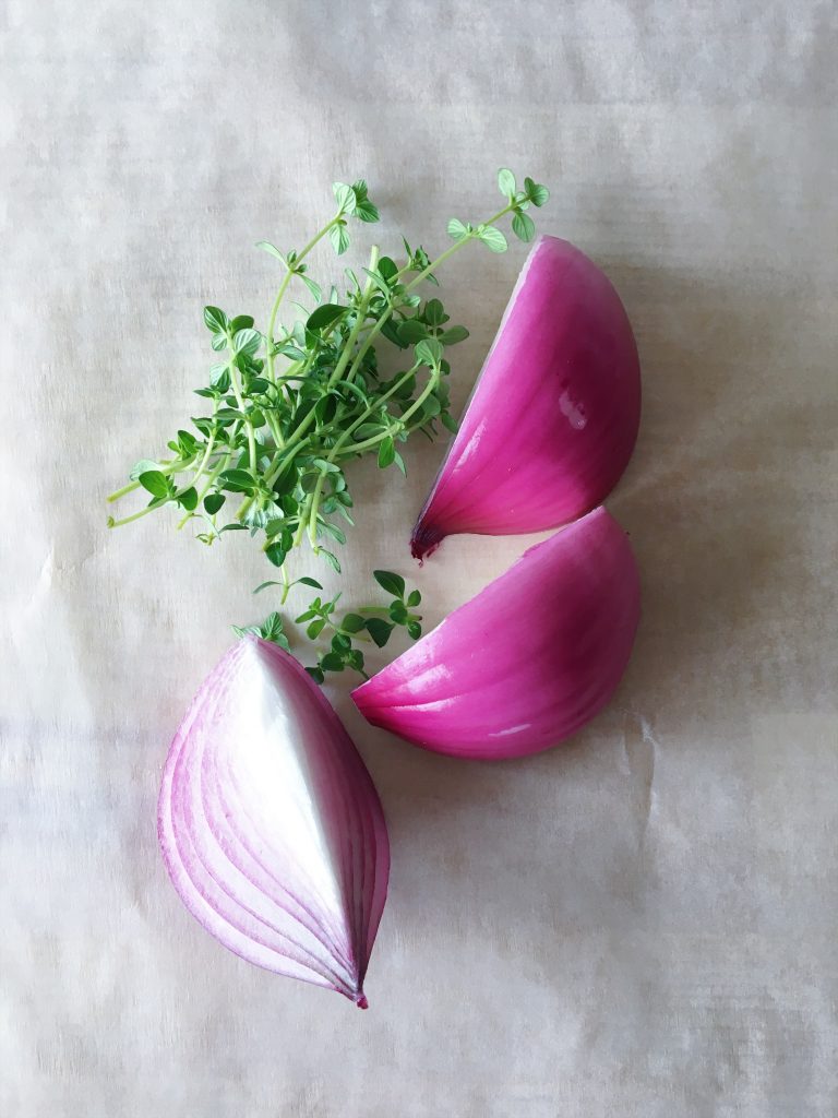 thyme and red onion on parchment paper for this miso chicken soup recipe