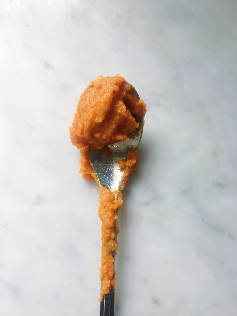 spoon of pureed pumpkin for pumpkin chocolate chip muffins