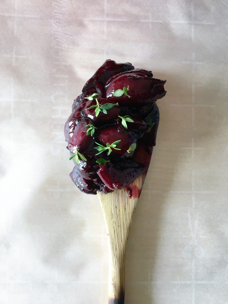 Roasted cherry dipping sauce on a wooden spoon